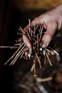 Man grabbing a heap of rusty nails