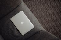 Kaboompics - Close up view of closed laptop lying on grey armchair