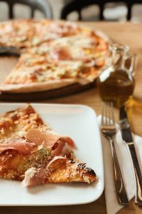 Kaboompics - Pizza with Prosciutto on the white plate