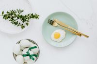Easter flat lay with green eggs and fried egg on a plate