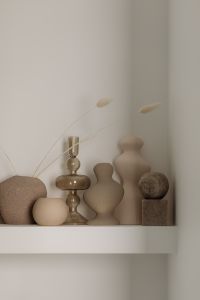 Kaboompics - Neutral Toned Decorative Vases and Sculptures on a White Shelf