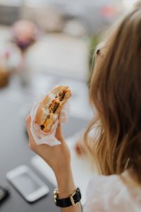 Kaboompics - A businesswoman eats a hamburger at work
