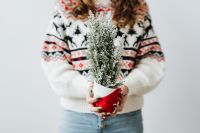 Kaboompics - Woman in a white Christmas sweater holds cypress