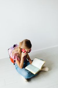 Kaboompics - Young girl uses phone and reads a book