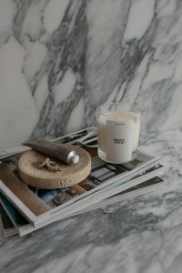 Kaboompics - Chic Home Decor UGC Scene with Scented Candle - Hand Cream and Jewelry on a Modern Magazine