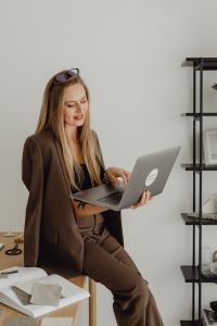 Kaboompics - Young entrepreneur dressed in brown suit holds laptop