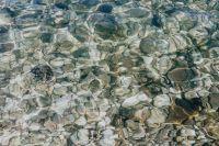 A close-up of stones in turquoise water, Isola, Slovenia
