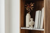 Books on a bookcase - marble shelves - vase - dried flower