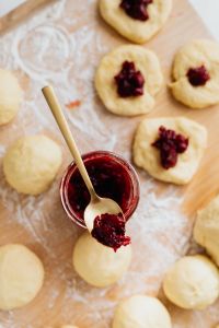 Kaboompics - Adding cherry marmalade to Polish donuts - Paczki