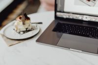 Kaboompics - Working with a laptop, meringue with whipped cream on white marble