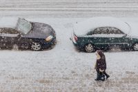 Snowy Street with Cars & woman walking along a sidewalk