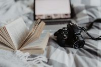 Kaboompics - A camera, MacBook, and a book waiting in bed