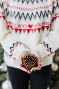 Kaboompics - Woman in a white Christmas sweater holds a cone