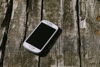 Kaboompics - White smartphone on a wooden background