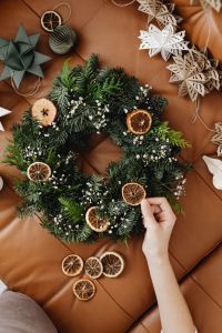 Kaboompics - Hand Decorating Christmas Wreath with Dried Orange Slices