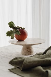 Kaboompics - Close-Up Red Apple with Dried Leaves on a Stone Pedestal, Neutral Home and Food Styling