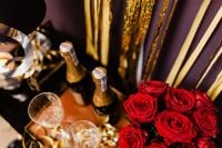 Kaboompics - Overhead New Year's Eve Table with Champagne, Red Roses and Gold Serpentine Decor