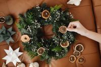 Kaboompics - Hand Decorating Christmas Wreath with Dried Orange