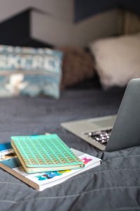 Kaboompics - Laptop with books on a bed