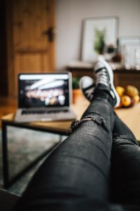 Kaboompics - Ripped Jeans and Sneakers Beside a Laptop on a Wooden Table