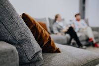 Kaboompics - Gray Sofa Texture and Brown Velvet Pillow with People Relaxing in the Background
