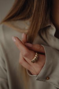 Kaboompics - Gold Ring on Woman's Hand Against Tan Silk Shirt