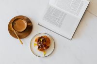 Kaboompics - Open Book, Coffee and Cinnamon Roll on White Table