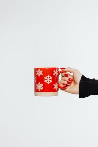 Kaboompics - Vertical Red Snowflake Mug Held in Hand, Minimal Christmas Prop with Generous Copy Space