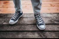 Kaboompics - Woman in black Converse sneakers and ripped jeans