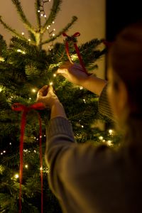 Kaboompics - Decorating Christmas Tree with Red Ribbon