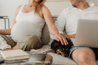 Kaboompics - Pregnant Couple Relaxing on a Sofa with Laptop and Pet