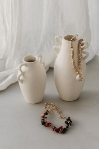 Kaboompics - Beaded Necklace Draped Over a Ceramic Vase