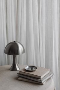 Kaboompics - Chrome Dome Table Lamp and Silver Bowl on Stacked Books, Minimalist Neutral Home Decor Still Life