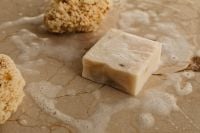 Kaboompics - Natural Soap Bar and Sea Sponge on a Wet Stone Surface