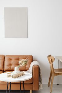 Kaboompics - Leather Sofa and Floral Coffee Table in a Bright Living Room, Vertical Home Decor Editorial