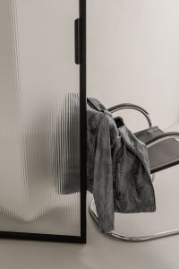 Kaboompics - Black Leather Jacket Draped on Chrome Chair by Glass