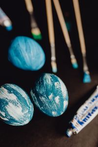 Kaboompics - Woman Painting Blue Easter Eggs