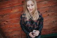 Kaboompics - Blonde woman with a can of coke by a wooden wall