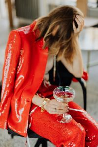Kaboompics - Relaxed Woman Touching Her Hair with Champagne in Red Suit