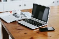 Kaboompics - Silver Laptop, Open Magazine and Smartphone on a Wooden Table