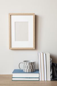 Kaboompics - Wooden Frame Mockup with Gray Patterned Mug, Books and Marble Decor
