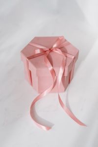 Light pink velvety box with satin ribbon on white marble