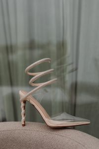 Kaboompics - Nude Spiral-Strap Stiletto Styled on a Curved Neutral Chair