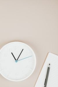 Kaboompics - White Clock beside Lined Notebook and Pencils