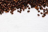 Kaboompics - Roasted Coffee Beans Along the Top Edge of a White Background for Cafe Branding