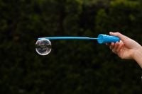 Kaboompics - Blue Bubble Wand with a Single Bubble against Dark Garden Background