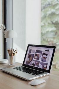 Kaboompics - Vertical Laptop Workspace with Design Inspiration on Screen, Desk Lamp and Pencil Cup