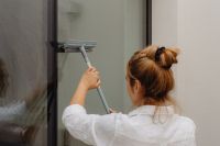 Kaboompics - Woman Washing a Large Window with a Squeegee