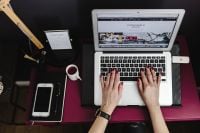 Kaboompics - Woman Typing on MacBook at Pink Desk, Overhead View