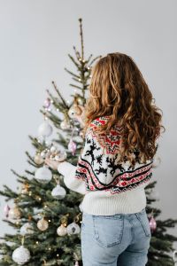 Kaboompics - Woman Decorating a Christmas Tree in a Cozy Fair Isle Sweater